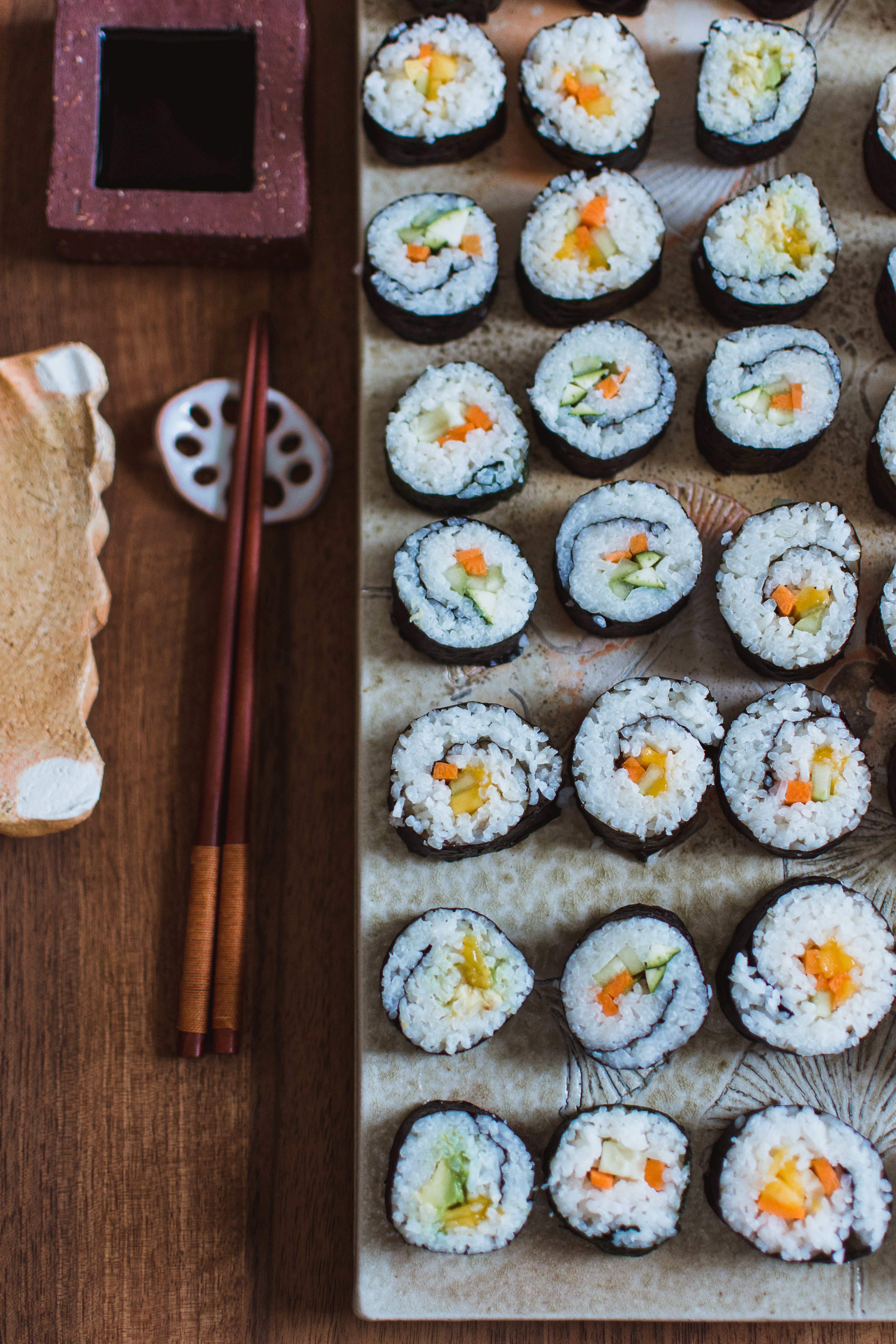 Een rechthoekig bord met drie rijen sushi