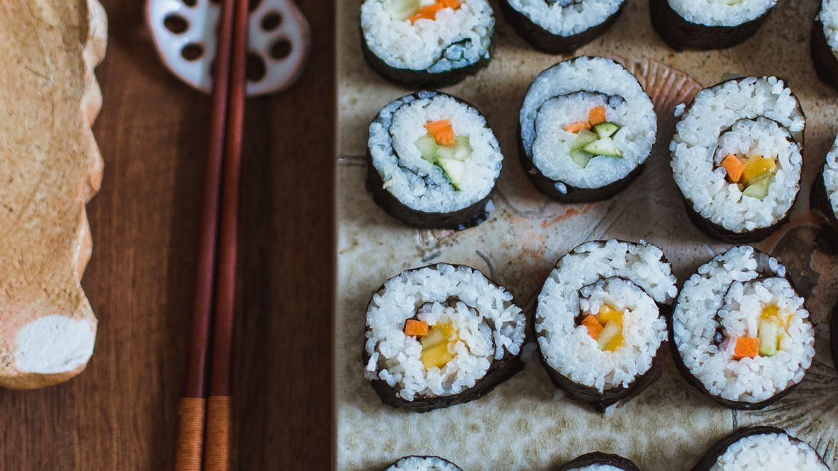 Een rechthoekig bord met drie rijen sushi