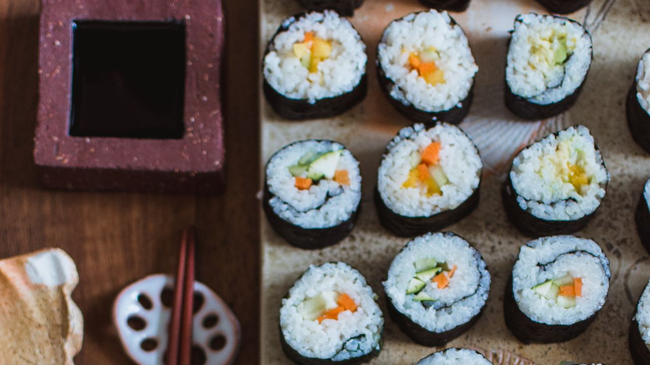 Een rechthoekig bord met drie rijen sushi