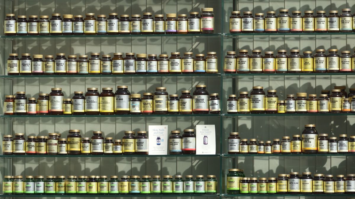 Een winkel stellage gevuld met potjes vitamines en supplementen